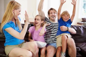 Family Watching Soccer on TV Celebrating Goal