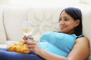 Overweight Woman At Home Eating Chips And Drinking Wine