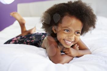 Cute Little Girl Lying On Tummy In Parent's Bed
