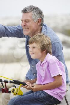 Young boy fishing with grandfather