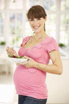 Pregnant woman eating salad