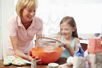 Grandmother And Granddaughter Baking Together At Home