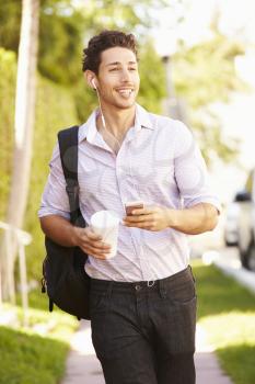 Man Walking Along Street To Work Listening To Music