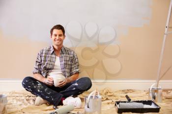 Man Taking A Break Whilst Decorating Room