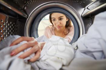 Woman Doing Laundry Reaching Inside Washing Machine