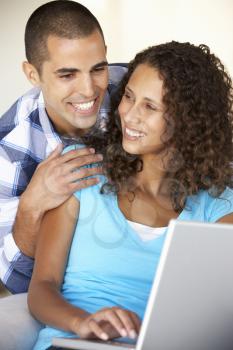 Young Couple Using Laptop Computer At Home