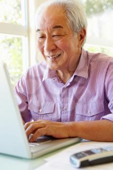 Senior Taiwanese man working on laptop