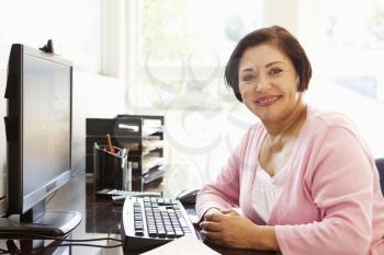 Senior Hispanic woman working on computer at home