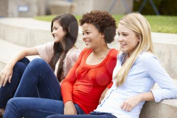 Teenage student girls sitting outdoors
