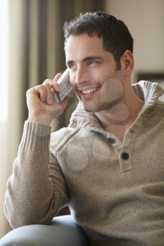 Young man talking on cordless phone at home