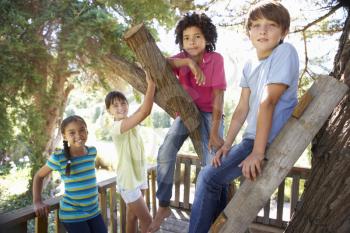Group Of Children Hanging Out In Treehouse Together
