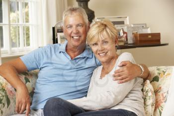 Mature Couple Sitting On Sofa At Home Together