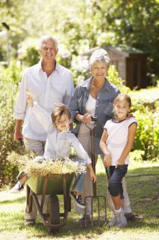 Grandchildren Helping Grandparents In Garden At Home