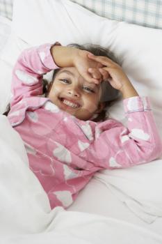 Young Girl Wearing Pajamas Lying In Bed