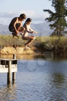 Two Children Jumping From Jetty Into Lake
