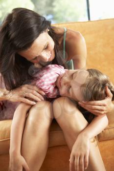 Tired Daughter Resting On nMother's Lap On Sofa