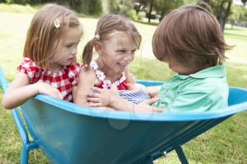 Three Children Sitting In Wheelbarrow