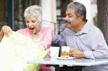 Senior Couple Enjoying Snack At Outdoor Caf After Shopping