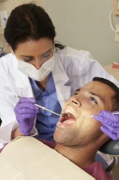 Man Having Check Up At Dentists Surgery