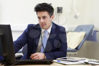 Male Consultant Working At Desk In Office