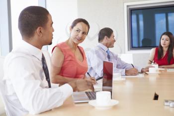 Four Hispanic Businesspeople Having Meeting In Boardroom