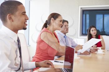 Four Hispanic Businesspeople Having Meeting In Boardroom