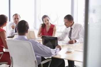 Five Businesspeople Having Meeting In Boardroom