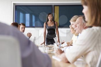 Group Of Businesspeople Meeting Around Boardroom Table
