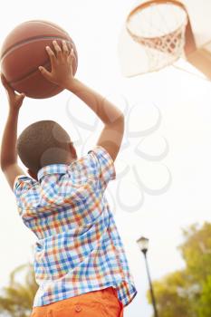 Boy On Basketball Court Shooting For Basket