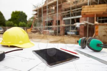 Close Up Of Plans And Digital Tablet On Building Site