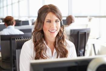 Young woman working in a call centre, looking at screen