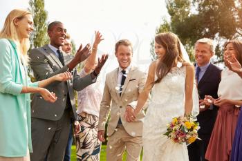 Guests Throwing Confetti Over Bride And Groom At Wedding