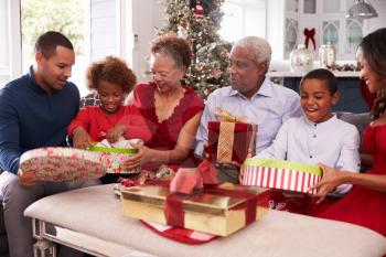 Family With Grandparents Opening Christmas Gifts