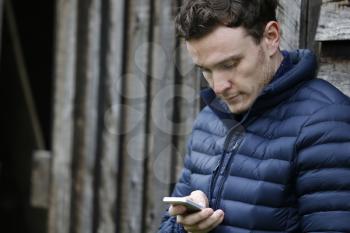 Man Outdoors Checking Mobile Phone