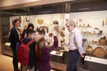 Students Looking At Artifacts In Case On Trip To Museum