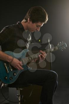 Man Playing Electric Guitar In Studio