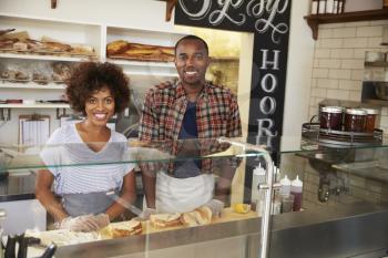 Black couple waiting behind the counter at a sandwich bar