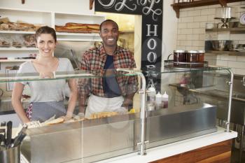 Mixed race couple waiting behind counter at a sandwich bar