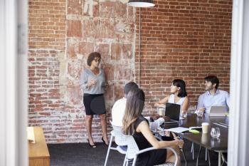 Mature Businesswoman Standing To Address Boardroom Meeting