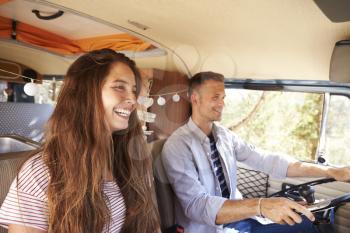 Happy couple driving a camper van on a road trip vacation
