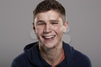 Teenage boy smiling to camera, head and shoulders portrait