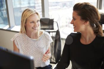 Businesswomen Working At Office Desk On Computer Together