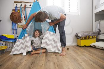 Father And Daughter Playing In Wigwam In Playroom