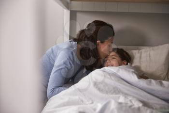 Mother Kissing Goodnight To Daughter At Bedtime
