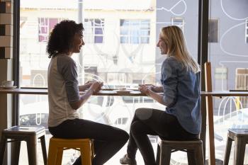 Two Female Friends Meeting In Coffee Shop