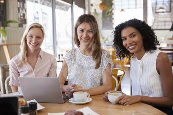 Portrait Of Three Businesswomen Meeting In Coffee Shop