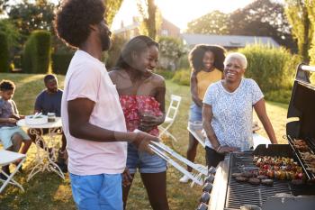 Adults talking at a multi generation family barbecue