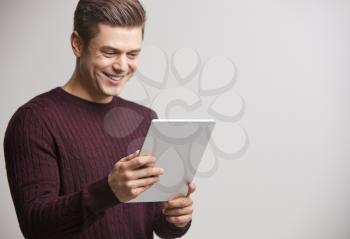 Smiling young white man holding a tablet computer