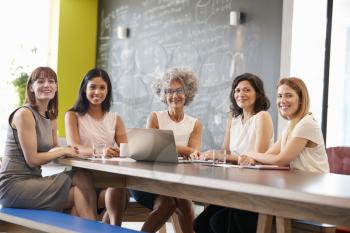 Female work colleagues at informal meeting looking to camera