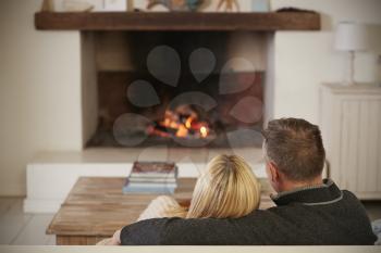 Romantic Couple Relaxing In Lounge Next To Open Fire